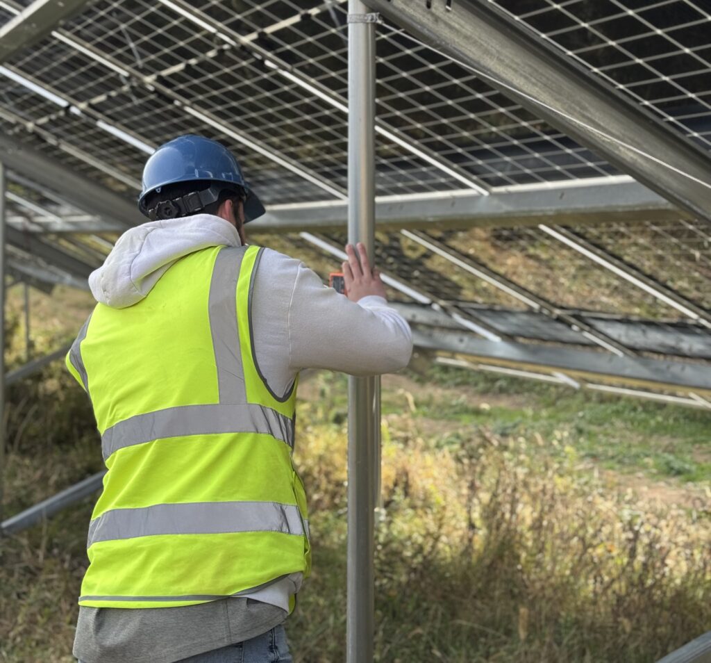 Image of a solar site worker testing solar racking for quality and safety.